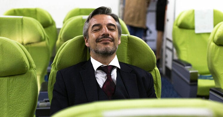 Caucasian business man relax sitting and sleep at seat in on airline cabin. he feeling happy in comfort space. travel abroad for working trip