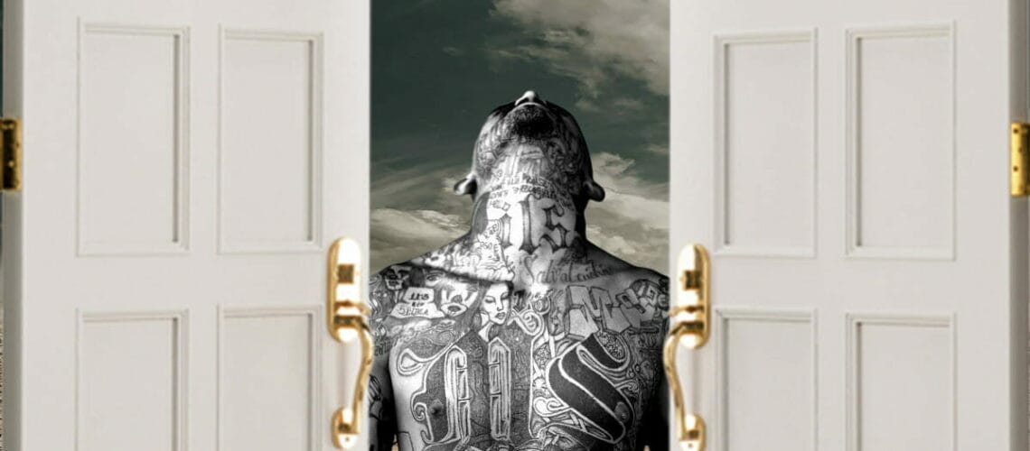 ms 13 gang member standing at open door to border between mexico and us